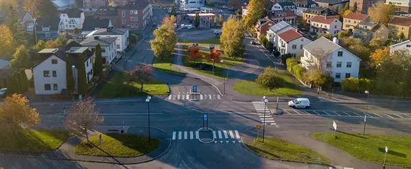 Korsning med övergångsställen. I bakgrund syns bostadshus och träd.